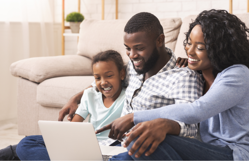 family of three looking at a computer