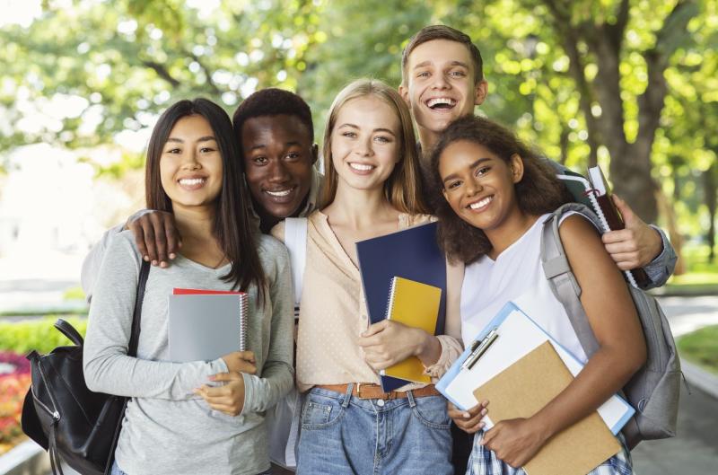 a diverse group of teenagers with school books