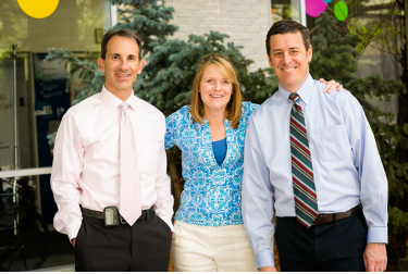 two men in ties and a woman 